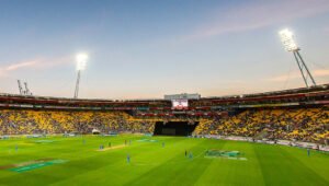 Hnry Stadium in Wellington lit up under floodlights during an evening T20 international, with players on the field