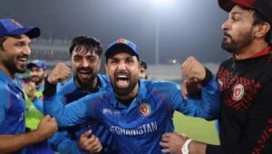 Afghanistan players Mohammad Nabi and Rashid Khan celebrating a win in blue ODI kit